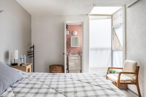 a bedroom with a bed and a chair and a window at Increible departamento en la del valle in Mexico City