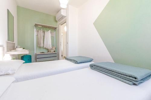 two beds in a room with a mirror at Skyfive Earth Apartment in Alghero