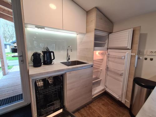 a small kitchen with a sink and refrigerator at Chalet Panorama near Efteling - with garden and swimmingpool Europarcs in Kaatsheuvel