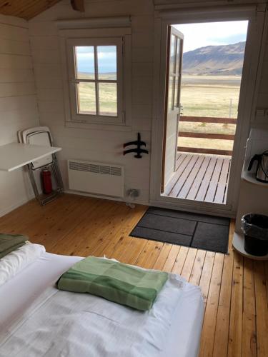 a bedroom with a bed and a large sliding glass door at Seljaland ferðaþjónusta in Búðardalur