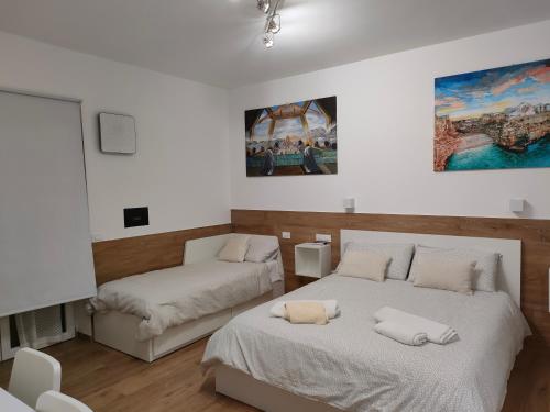a bedroom with two beds and a painting on the wall at IL CENTRO LUXURY SUITES in Bari