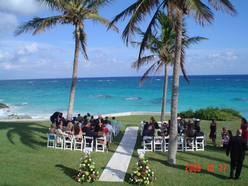 a wedding ceremony on the beach next to the ocean at Coco Reef Bermuda in Mount Pleasant