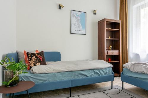 a bedroom with a blue bed and a book shelf at Baltivia haus in Gdynia