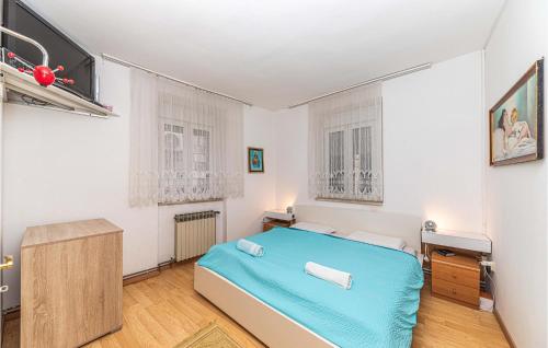 ein Schlafzimmer mit einem blauen Bett in einem Zimmer in der Unterkunft Gorgeous Home In Seget Donji With Wifi in Trogir