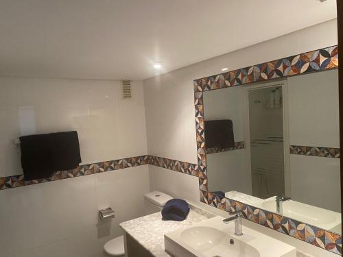 a bathroom with a mirror and a sink and a toilet at Beautiful refurbished apartment Duquesa port in Casares
