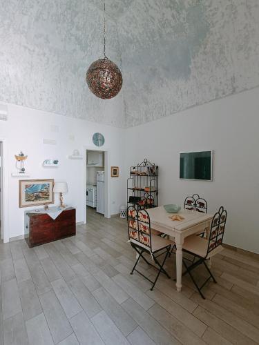 ein Wohnzimmer mit einem Tisch und Stühlen in der Unterkunft Valerie Apartment in Gallipoli