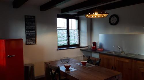 a kitchen with a wooden table and a red refrigerator at GITE Chambre SPA Privé DE L'ANCIENNE FERME in Vallières