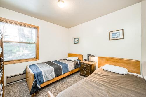 two beds in a room with a window at Pandora in Shaver Lake