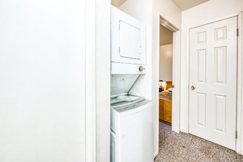 a small white refrigerator in a room with a door at Pandora in Shaver Lake