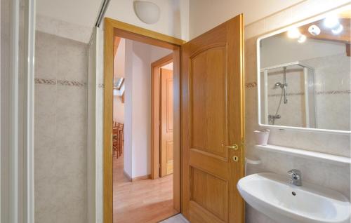 a bathroom with a sink and a wooden door at Beautiful Apartment In Roncegno Terme With Wifi And 2 Bedrooms in Marter di Roncegno