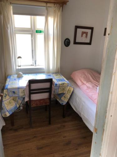 a bedroom with a bed and a table and a window at Seljaland ferðaþjónusta in Búðardalur