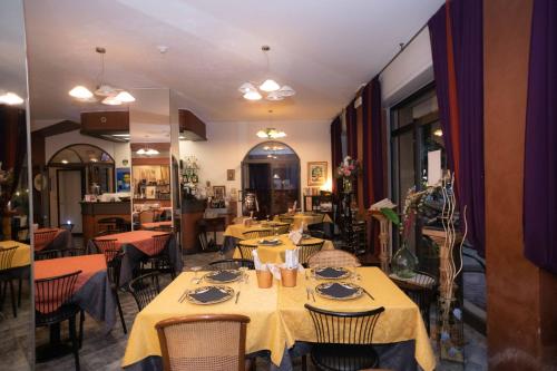 a restaurant with tables and chairs in a room at Hotel Magnolia in Albenga