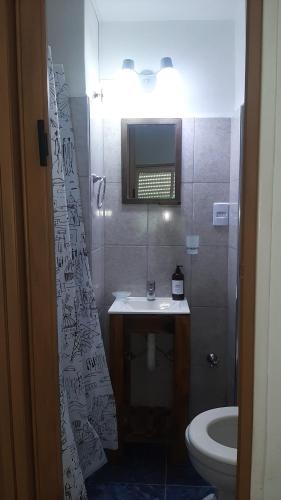 y baño con lavabo, aseo y espejo. en departamento en almagro, 2 huéspedes en Buenos Aires