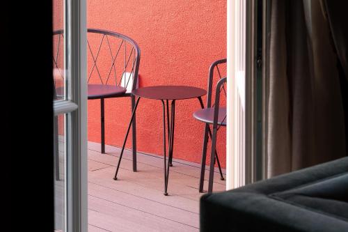 a couple of chairs and tables on a balcony at AP Dona Aninhas in Viana do Castelo
