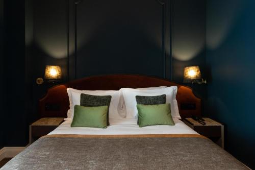 a bedroom with a bed with two green pillows at AP Dona Aninhas in Viana do Castelo