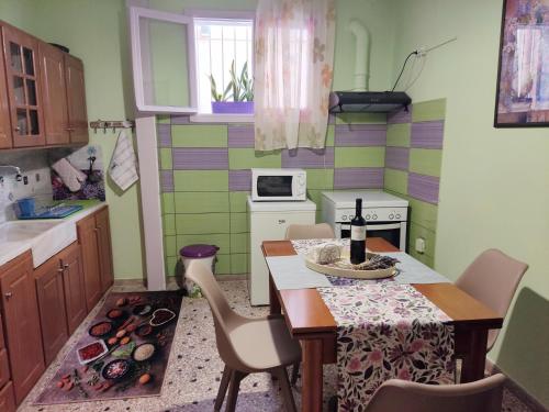 a kitchen with a table and chairs and a kitchen with green at Napier Apartment in Argostoli