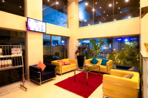 a lobby with couches and a tv in a building at Citrus Hotel Cunningham in Bangalore