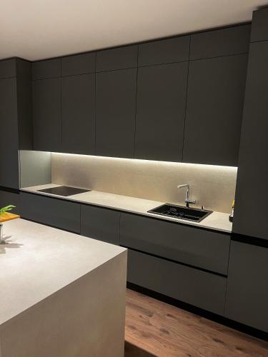 a kitchen with black cabinets and a sink at Luxury home beach apartament in Split, Croatia in Split