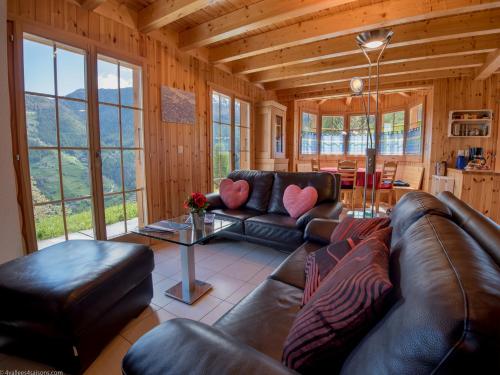 a living room with a leather couch and a table at Chalet Colonia in La Tzoumaz