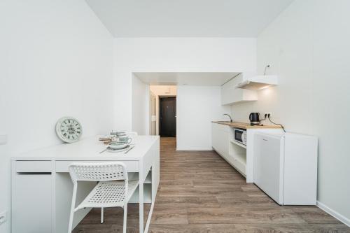 a kitchen with white cabinets and a white table and chairs at Kalniečių st 126A Kaunas Students Home LT in Kaunas