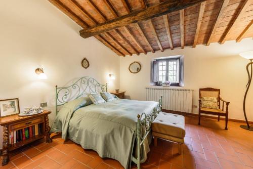 グレーヴェ・イン・キアンティにあるTenuta Poggio ai Mandorliの木製の天井が特徴のベッドルーム1室(ベッド1台付)