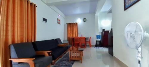 a living room with a couch and a fan at The Coorg Heaven in Madikeri