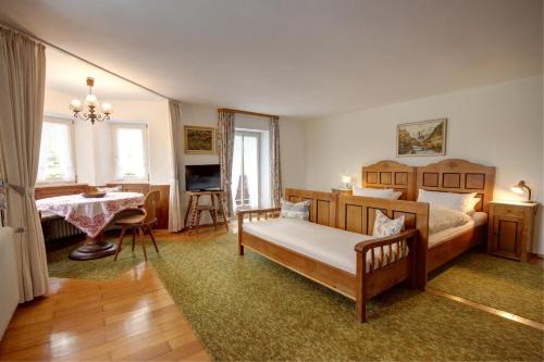 a bedroom with a bed and a table and a television at Bräulerhof in Bayerisch Gmain