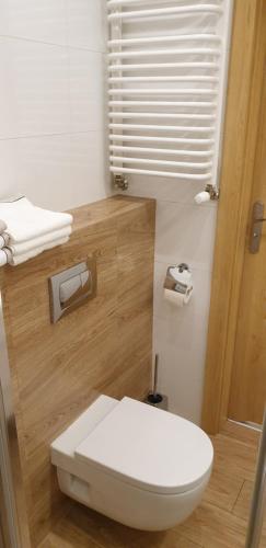 ein Bad mit einem weißen WC und einem Fenster in der Unterkunft River Deluxe Atal Towers Apartment in Breslau