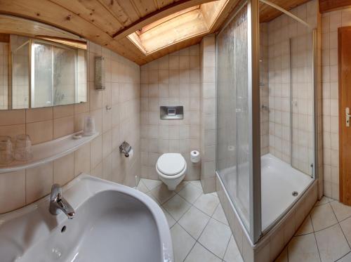 a bathroom with a tub and a toilet and a shower at Bräulerhof in Bayerisch Gmain