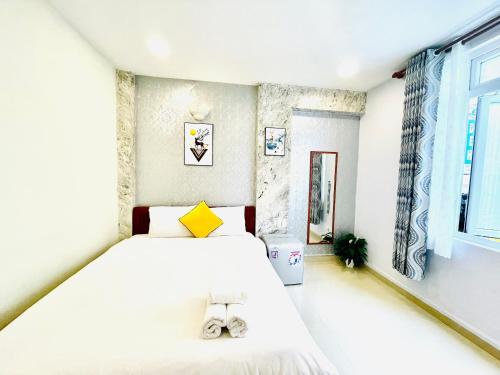 ein Schlafzimmer mit einem großen weißen Bett und einem Fenster in der Unterkunft Dalat Colico Hotel in Da Lat