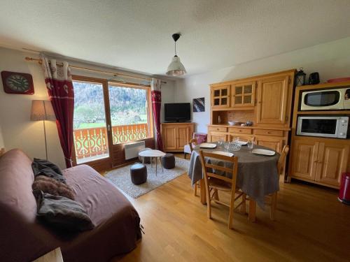 Il comprend un salon avec une cuisine et une table à manger. dans l'établissement Appartement T2 calme avec balcon, proche ski-bus et village - FR-1-624-37, à Samoëns