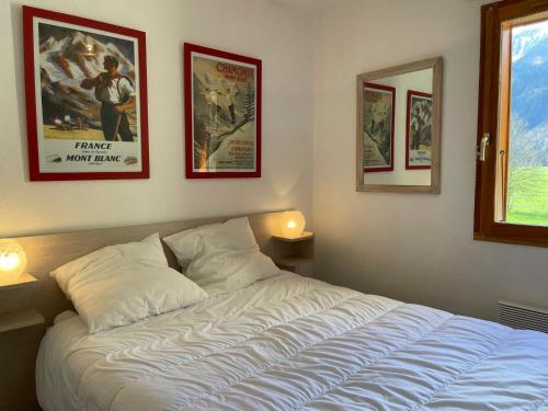 a bed in a bedroom with posters on the wall at Appartement Samoëns, 2 pièces, 5 personnes - FR-1-624-37 in Samoëns
