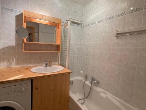 ein Badezimmer mit einem Waschbecken, einer Badewanne und einem Spiegel in der Unterkunft Appartement Samoëns, 2 pièces, 5 personnes - FR-1-624-37 in Samoëns