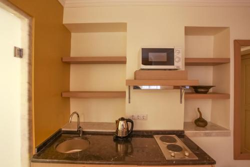 a kitchen with a sink and a microwave at Stunning Studio Flat with Jacuzzi near Hadrian's Gate in Antalya