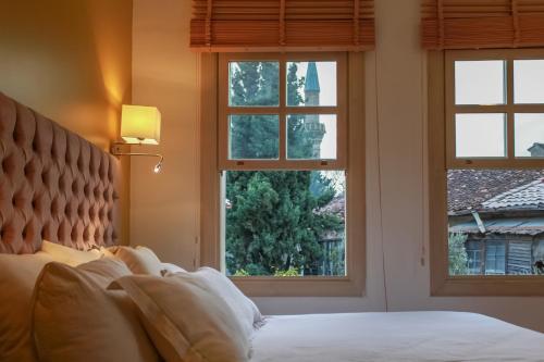 a bedroom with a bed and three windows at Stunning Studio Flat with Jacuzzi near Hadrian's Gate in Antalya