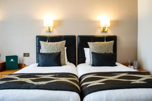 two beds sitting next to each other in a room at Lancaster House Hotel in Lancaster