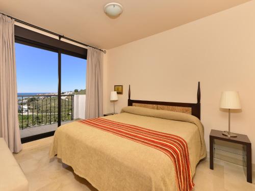 een slaapkamer met een bed en een groot raam bij Apartamento vista mar lateral in Torrox Costa