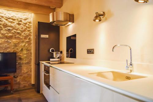 um balcão de cozinha com um lavatório e uma televisão em El Call LEstudi en la judería de Besalú em Besalú