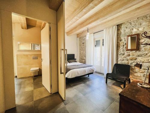 a bedroom with a bed and a stone wall at El Call, LEstudi en la judería de Besalú in Besalú