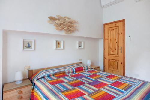 a bedroom with a bed with a colorful comforter at Casa zagare sul mare in Levanto