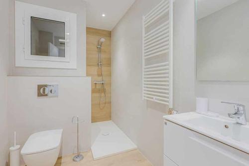 a white bathroom with a toilet and a sink at Apartamento Condal in Blanes