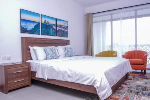 a bedroom with a large bed and two chairs at TULIA BEACH HOUSE, AT SULTAN PALACE in Kilifi