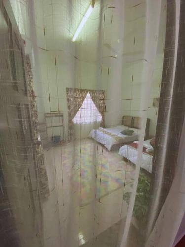 an unfinished room with two beds and a window at Batu Pahat Hill View Homestay in Batu Pahat