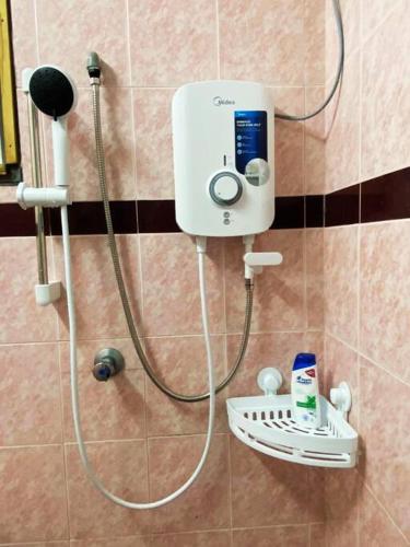 a shower with a shower head in a bathroom at Batu Pahat Hill View Homestay in Batu Pahat