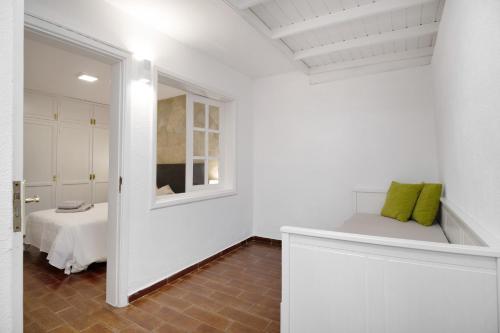 Una habitación blanca con una cama y una ventana. en Apartamento White Sun, en Playa Honda