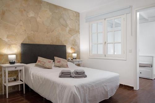 - une chambre avec un grand lit et des serviettes dans l'établissement Apartamento White Sun, à Playa Honda