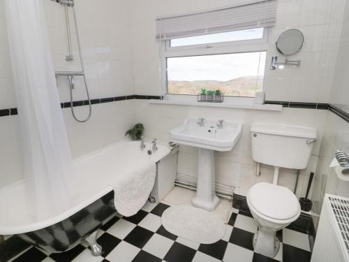 a white bathroom with a sink and a toilet at Dulas in Llandudno Junction