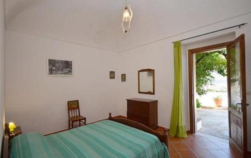 カステッルッツォにあるB&B Raggio Verdeのベッドルーム1室(ベッド1台付)、スライド式ガラスドアが備わります。