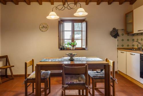 a kitchen with a wooden table and chairs and a window at Tenuta Poggio ai Mandorli in Greve in Chianti