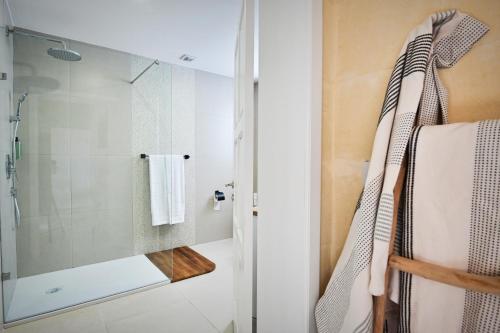 a bathroom with a shower with a glass door at Ogygia Suites Gozo in Għarb